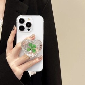 Detailed close-up of heart-shaped phone grip with green clover and silver foil inlay