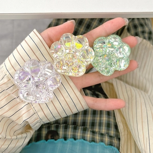 Close-up of three glittery cat paw phone sockets with iridescent sequins held in hand