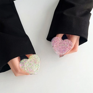 Detailed view of heart-shaped glitter phone grips with colorful sequins held by hand