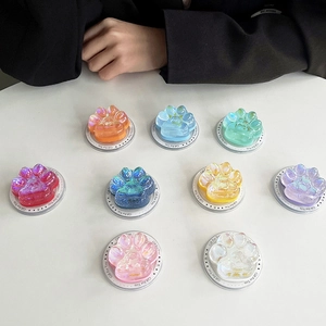 Lot de 9 supports de téléphone colorés en résine patte de chat sur table blanche