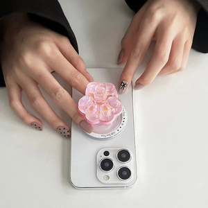 Support de téléphone patte de chat irisée rose tenu par des mains avec un nail art élégant