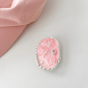 Detail eines rosa Harz-Handyhalters mit Schmetterlingen, Kristall und Hammerschlagrand