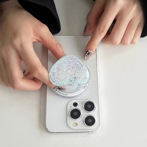 Detail of a sparkling heart Magsafe phone grip featuring glitter and side text