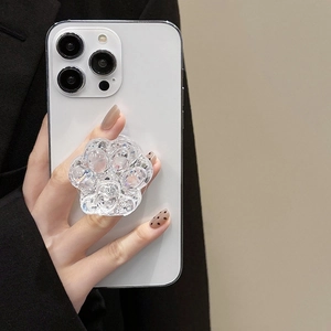 Detail of transparent glitter cat paw phone grip holder on white smartphone