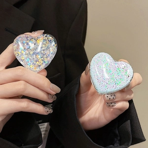 Detail of heart-shaped glitter phone grips with colorful sequins and purple shimmer