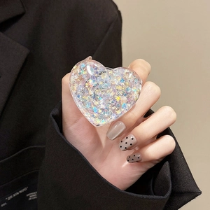 Detailed macro shot of transparent heart phone socket with colorful glitter and sequins