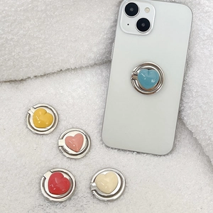 Solid color heart-shaped phone ring holders in 5 colors on soft white texture background