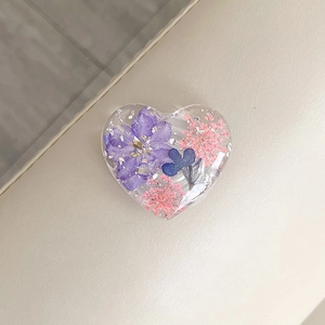 Detail of heart phone grip with purple dried flowers and silver foil in clear resin