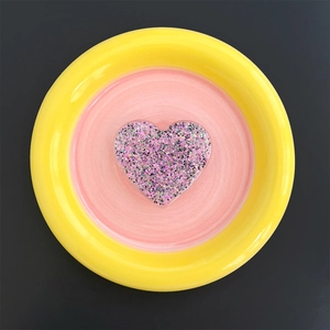 Detail of a heart-shaped glitter phone socket with sparkling pink and purple sequins