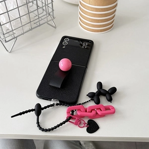 Dettaglio custodia in pelle nera per Samsung Z Flip con anello rosa e ciondolo a cane