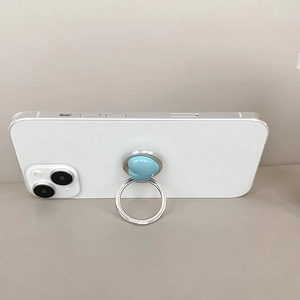 Foldable light blue heart phone ring holder on white smartphone with metallic silver rim