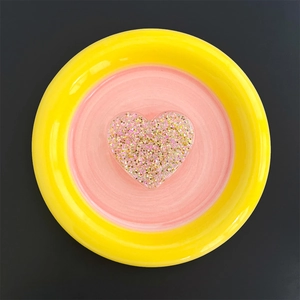 Close-up of heart-shaped glitter phone stand with pink and gold sequins in resin