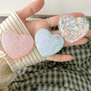 Close-up of glitter heart phone grip sockets with colorful sequins and shiny finish