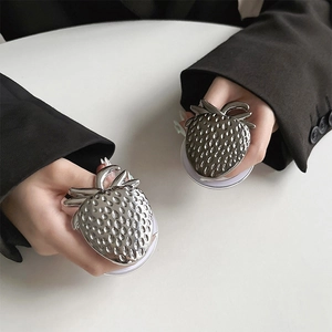 Detail of silver strawberry magnetic phone grip with metallic texture and sleek finish