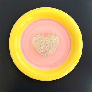 Macro detail of round phone socket featuring a sparkly glitter heart on pink and yellow base