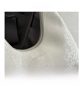 Macro detail of white snakeskin texture and silver zipper on luxury tote bag