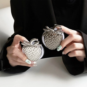Detail of silver and gunmetal strawberry-shaped magnetic phone sockets with textured finish