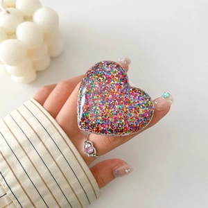Detail of colorful glitter heart phone grip holder with shiny sequins on transparent base
