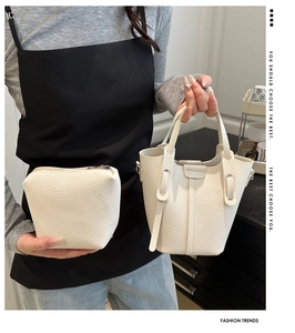 Detail of ivory lychee pattern bucket bag and zipper pouch set with metal hardware