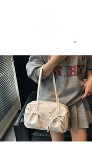 Detail of cream white tote bag with elegant bow knots and stylish pleated pocket