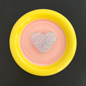 Macro shot of heart-shaped glitter phone grip with iridescent sequins in clear resin