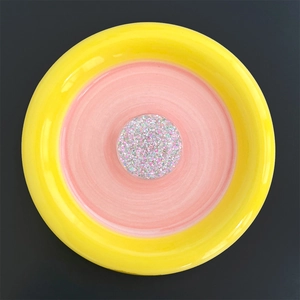 Macro detail of round phone socket with colorful glitter flakes on a ceramic plate