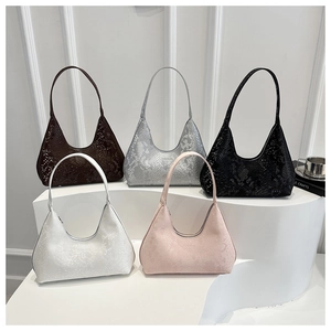 Close-up of five snake-embossed hobo bags in assorted colors on a minimalist display