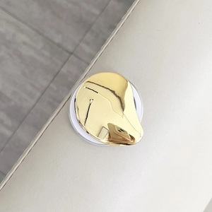 Close-up of liquid-effect metallic heart phone holder with polished gold plating finish