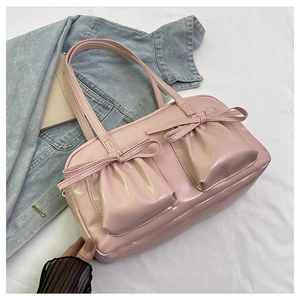 Dettaglio borsa a mano rosa chiaro in pelle verniciata con fiocchi in stile Balletcore