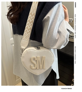 Detail of white heart-shaped PU leather bag with woven strap and SM logo detail