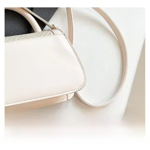 Macro detail of creamy leather handbag featuring premium woven texture and sleek metal clasp