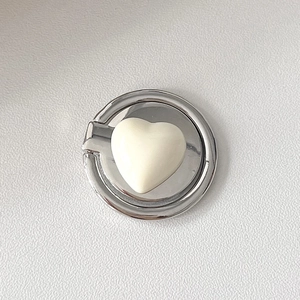 Detail showing creamy heart inlay on polished silver metallic phone ring holder base