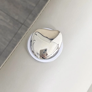 Close-up of heart-shaped silver magnetic phone grip with a polished mirror finish