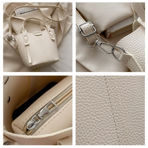 Detail view of cream leather bucket bag texture, silver hardware and inner pouch