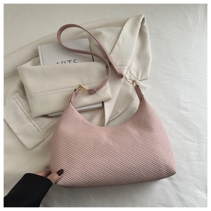 Détail de la texture tissée rose sur un sac hobo minimaliste avec boucle en métal doré