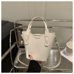 Detailed view of white litchi pattern bucket bag with double handles and strap