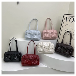 Close-up of glossy shoulder bags with bow pockets in six stylish colors on display