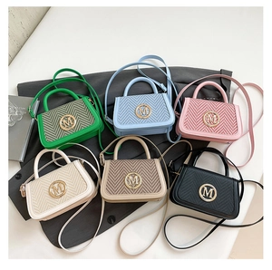 Flat lay of small crossbody box bags in six assorted colors with woven texture details
