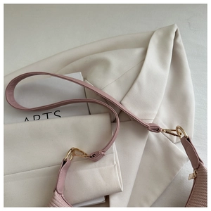 Gros plan détaillé du sac en tricot rose avec boucle dorée et bandoulière en cuir