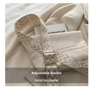 Close-up of jacquard geometric strap with adjustable silver buckle for crossbody bag