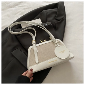 Close-up of white leather and beige woven fabric detail on shell-shaped shoulder bag