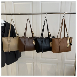 Detailed view of four colorful tote bags with decorative silk scarves on a hanging display