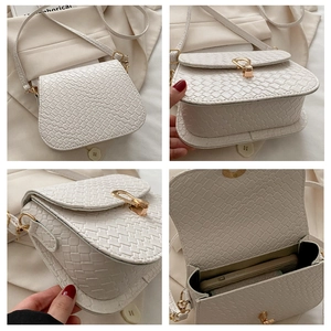 Detail view of white woven saddle bag with gold metal buckle and interior phone space
