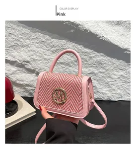 Detailed view of a pink leather crossbody bag featuring gold M hardware and woven panel