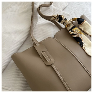 Detail of khaki tote bag with reinforced stitching and decorative vintage silk scarf handle