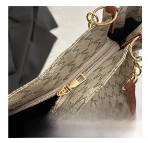 Detail of smooth metal zipper and classic letter print on the beige shoulder bag