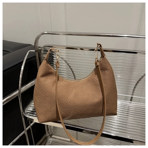 Detailed view of brown woven texture and adjustable gold buckle on the shoulder bag