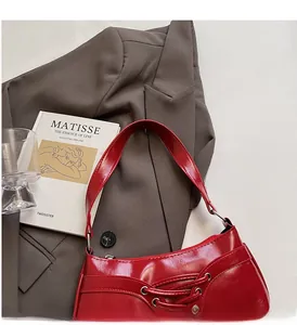 Detail of burgundy patent leather baguette bag with ballet-style lace-up ribbon design
