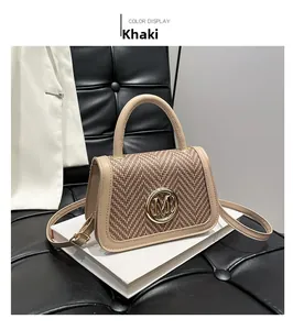 Close-up of khaki patchwork box bag with woven flap and gold M-letter metal buckle