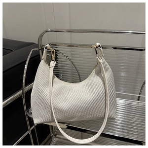 Detail of white woven crescent shoulder bag with golden hardware and leather strap